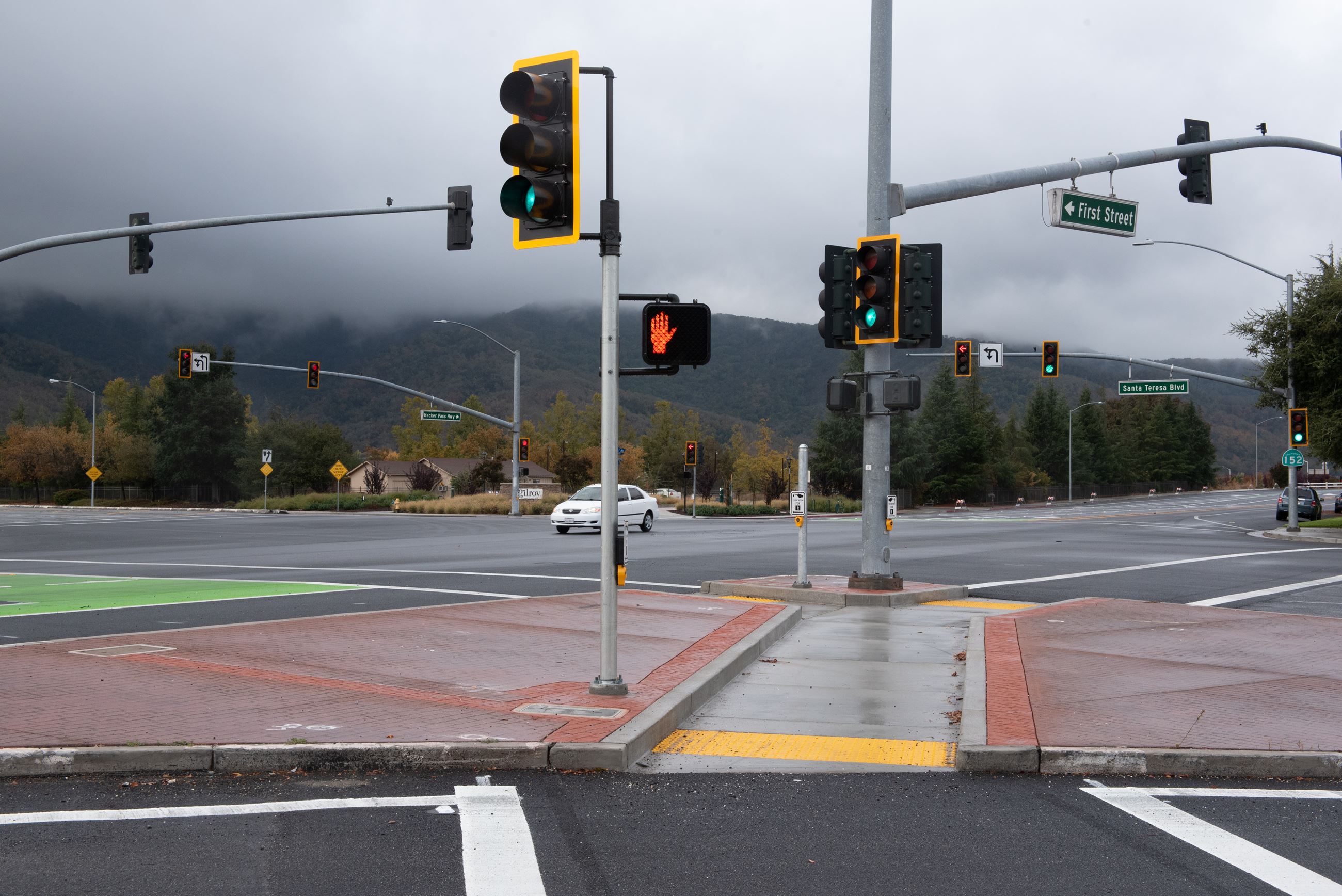 Signalized intersection with pedestrian crosswalks, curb ramps, traffic signals at street corner